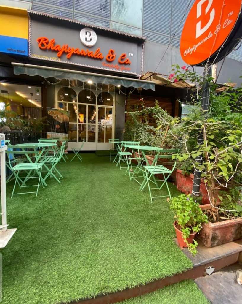 Outdoors, a cafe setup exudes charm. The wrought-iron cafe chairs and foldable tables create an inviting atmosphere, where patrons can relish moments of leisure in style by Kernig Krafts.
